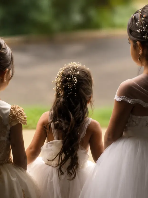 Three flower girls from behind, every updo braided and pinned to match