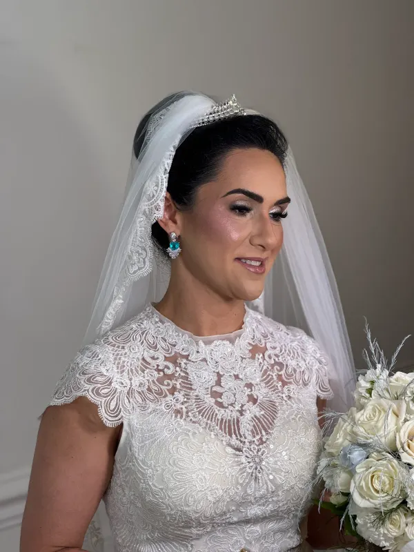Bridal hair set under a tiara and veil, the shape kept low and clean