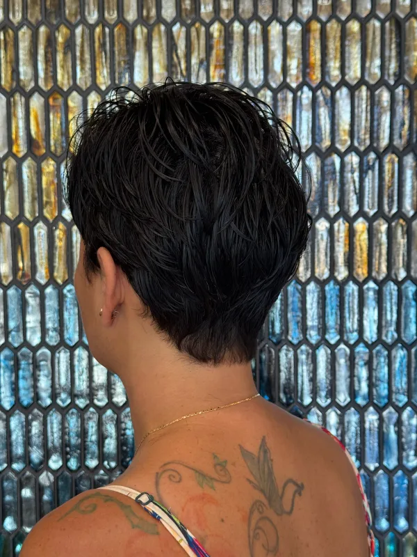 Dark pixie taken close at the nape, the length kept piecey through the top