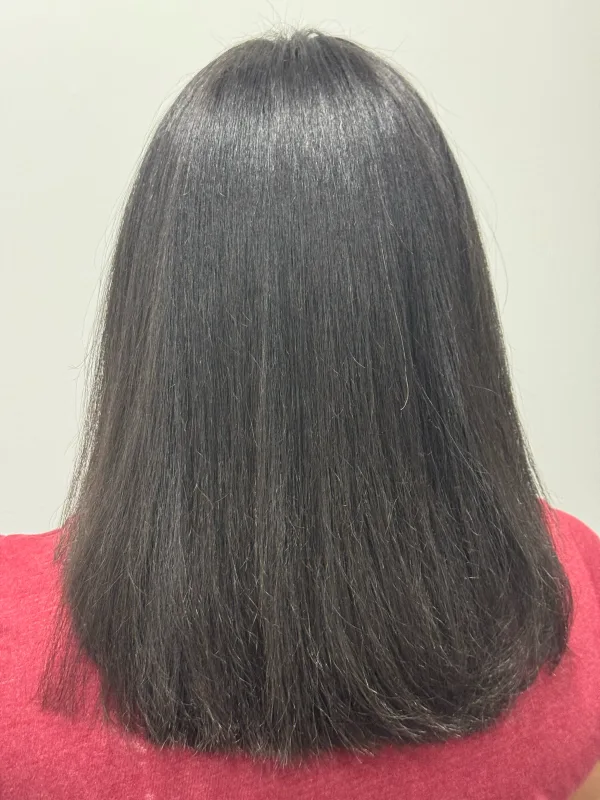 After the smoothing: the same hair straight and glossy, falling to the shoulder